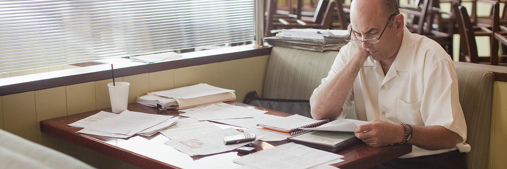 a restaurant owner doing paperwork at a booth